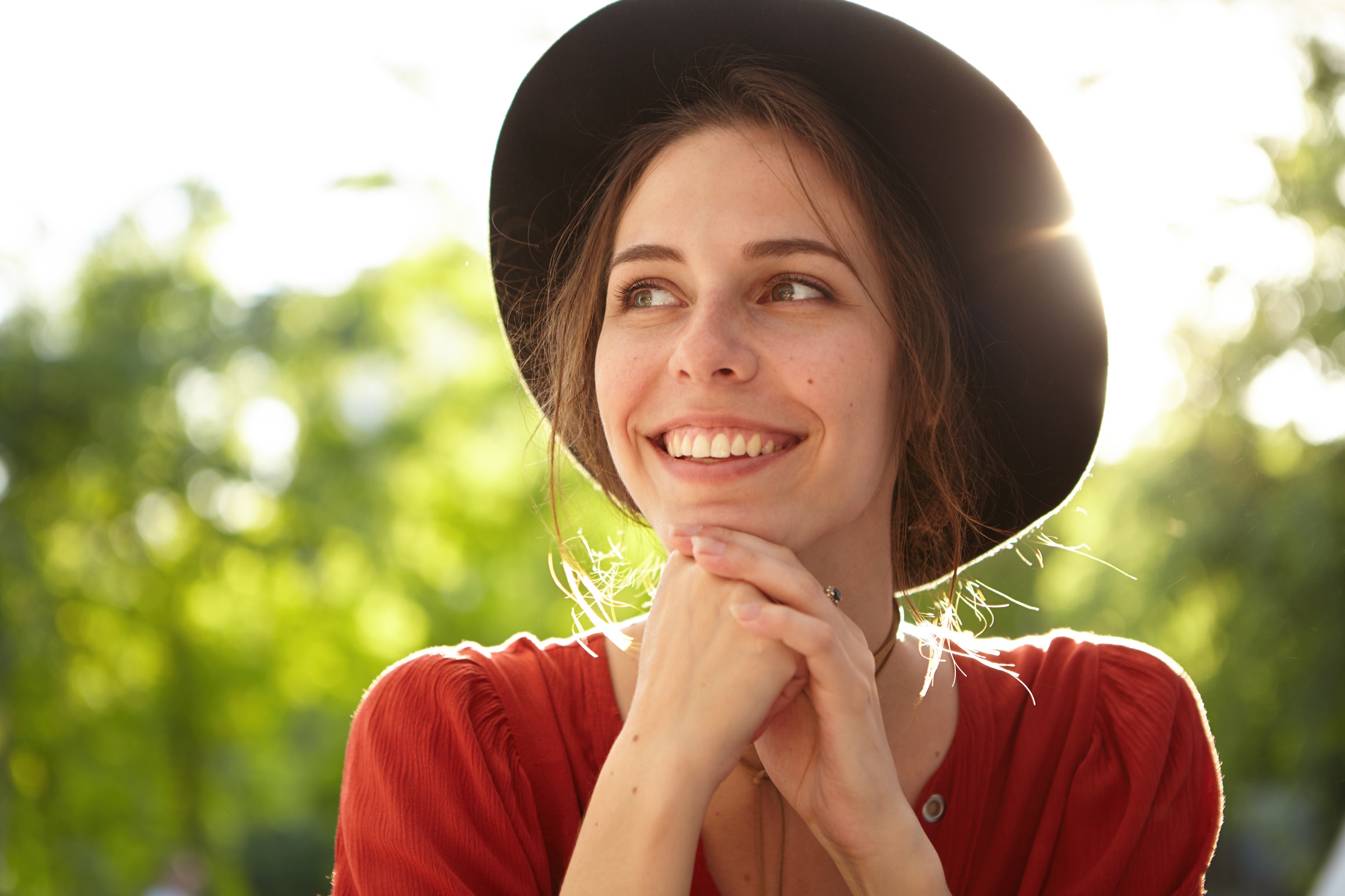 Woman smiling while outdoors in a hat