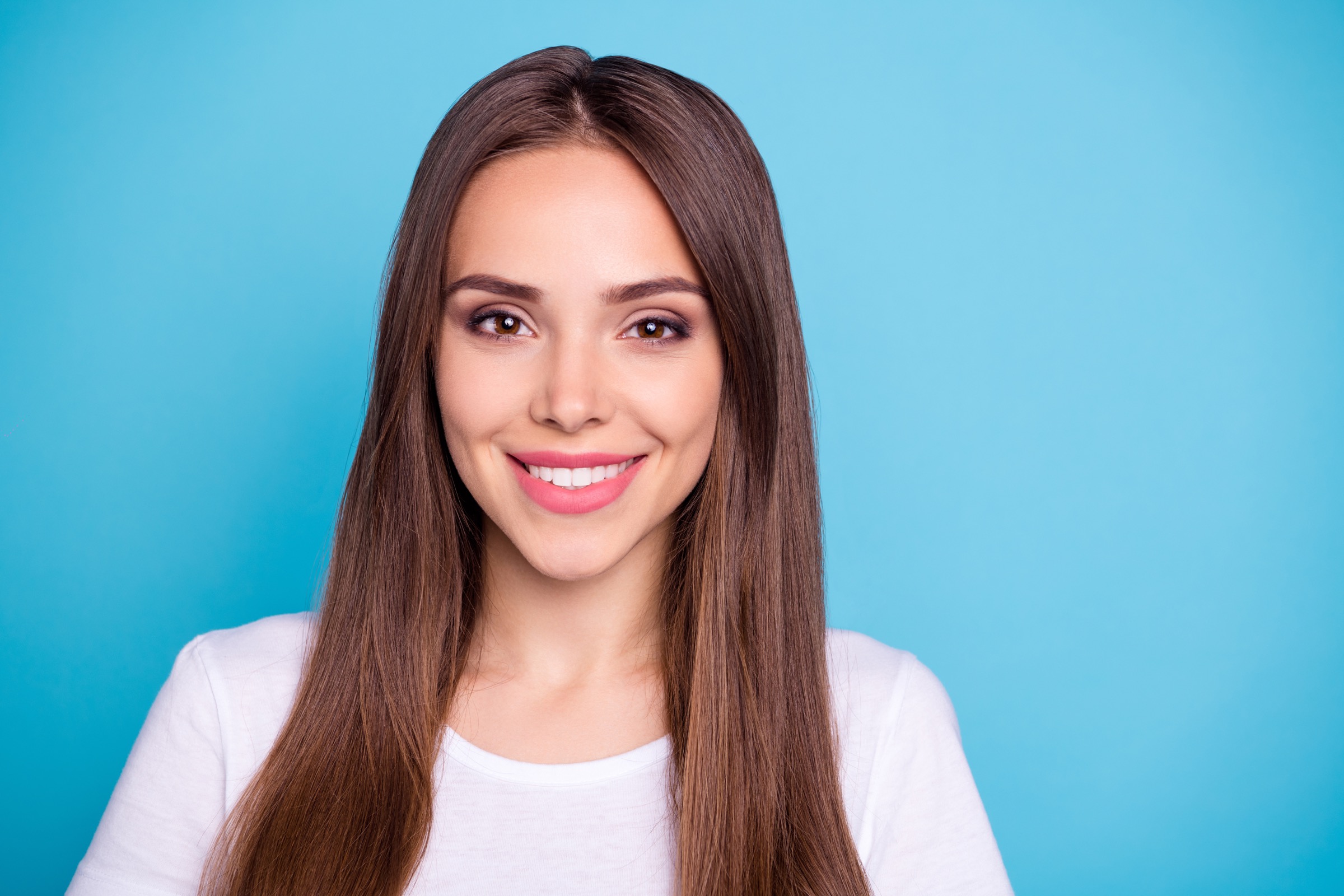 Woman smiling while in front of a blue background
