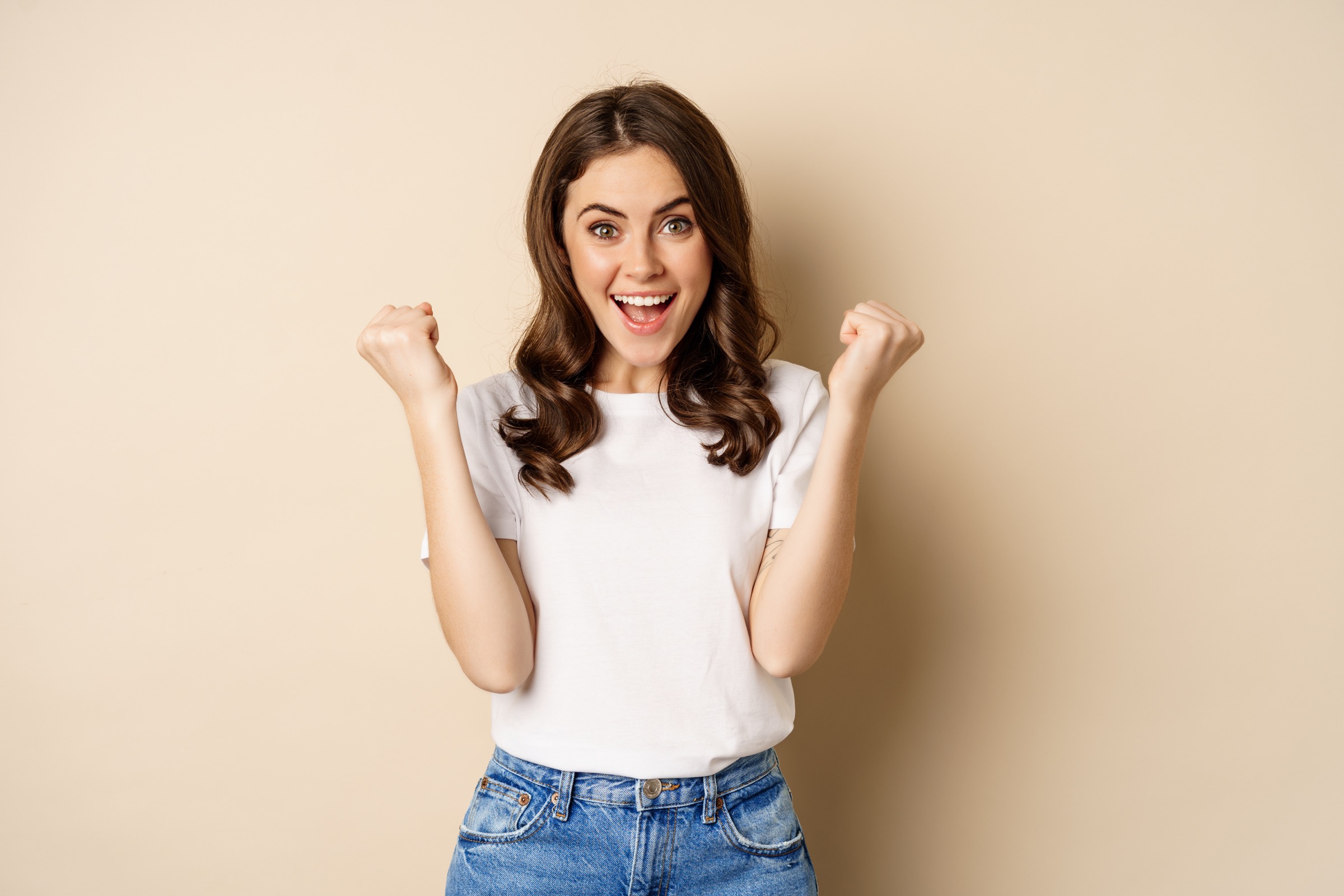An excited young woman fist pumping